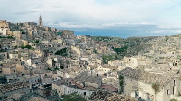 Panoramatický pohled typické kamenů (Sassi di Matera) a kostel Matera pod modrou oblohou, umělecký styl. Matera v Itálii Unesco Evropské hlavní město kultury 2019 — Stock video