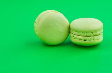 İki yeşil pasta macaron yeşil arka planda, maccarone tatlı tatlı
