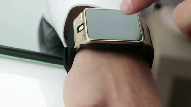 Człowiek za pomocą jego aplikację smartwatch w biurze — Wideo stockowe