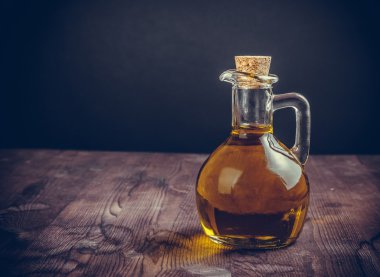 ahşap masa arka plan üzerinde tıpa ile zeytinyağı konteyner şişe