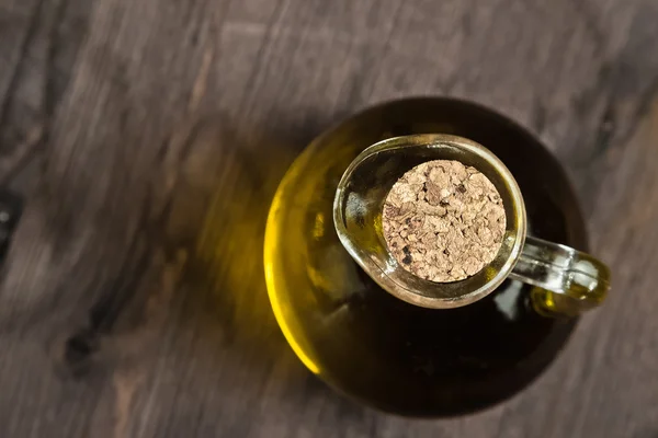 View top of olive oil container bottle with stopper on wood table background — Stock Photo, Image