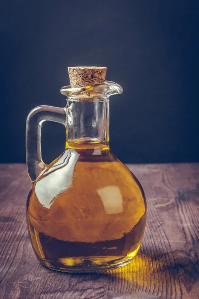 Olijfolie container fles met kurk op houten tafel achtergrond, vintage stijl — Stockfoto