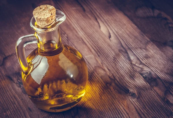 Vue sur le dessus de la bouteille de récipient d'huile d'olive avec bouchon sur fond de table en bois, style vintage — Photo