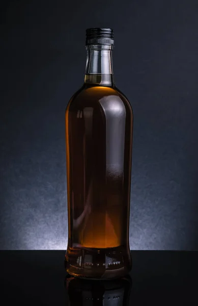 Whiskey bottle on black background, cool atmosphere — Stock Photo, Image