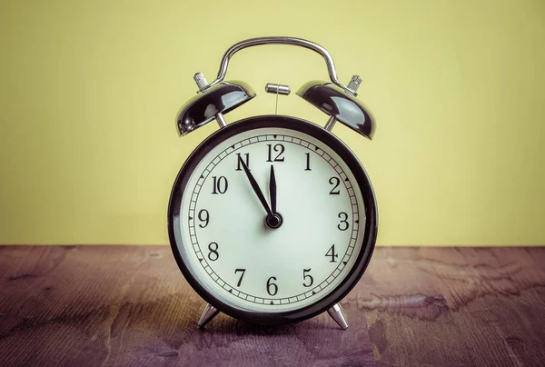 Já são doze horas, hora de acordar para o almoço, vintage velho relógio de alarme metálico preto — Fotografia de Stock