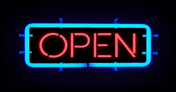 flickering blinking red and blue neon sign on black background, open shop bar sign