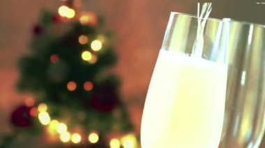 şampanya flüt ile altın altın sıcak zemin üzerine altın soyut yanıp sönen bulanık Noel ağacı ışıkları bokeh baloncuklarla içine dökme Noel şenlikli tatil 