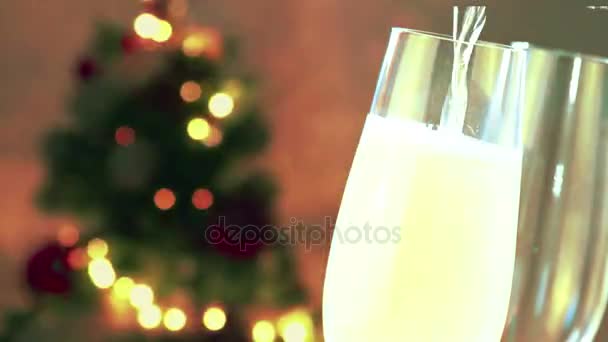 Hälla champagne i flöjter med gyllene bubblor med gyllene abstrakt blinkande suddig julgran lampor bokeh på guld varma bakgrund, festlig jullov — Stockvideo