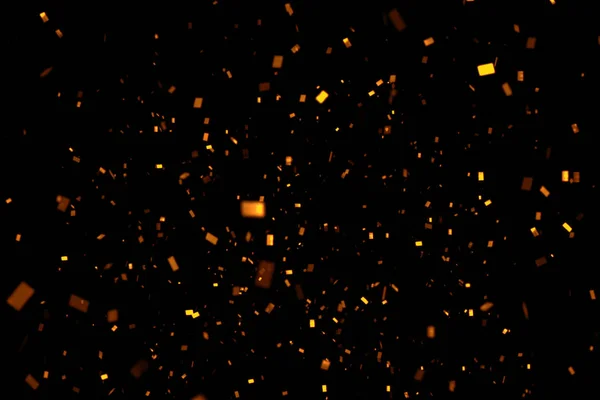 falling gold sparkle glitter foil confetti, on black background, happy new year holiday and festive fun