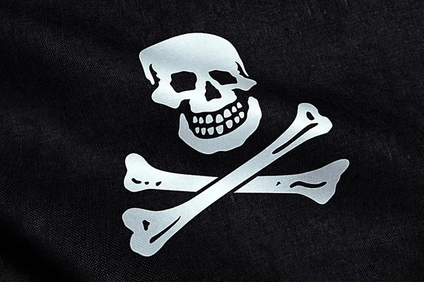 Waving fabric texture of the pirate flag waving in wind, calico jack pirate symbol, hacker and robber — Stock Photo, Image