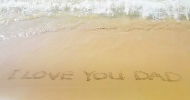 Goldenen Sand mit Strand und tropischen Meereswellen Bewegung, schreiben Sie Text auf Sand ich liebe dich Papa, liebe Familie — Stockvideo