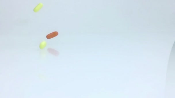 Médical, vitamines, compléments alimentaires pilules tombant au ralenti sur fond blanc, régime de soins de santé — Video