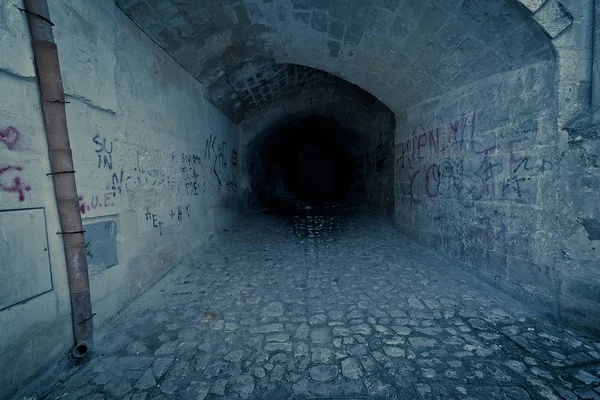 Opuszczony ciemny tunel klaustrofobiczny i przerażający, z zapisu na ceglany mur — Zdjęcie stockowe