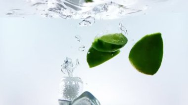 kireç dilim meyve splash beyaz kokteyl ve beyaz arka plan, eğlenceli, beslenme ve içki ağır çekimde atış cam, içme suyu içine düşme