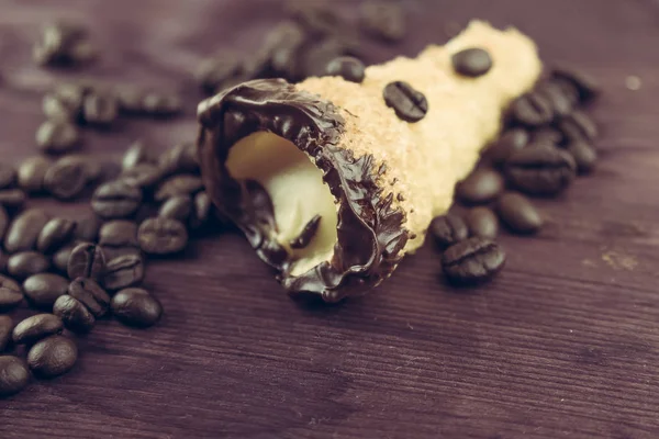 Вкусный сицилийский каннеллино каннеллино сладкий с кондитерским фундуком возле кофейных зерен — стоковое фото