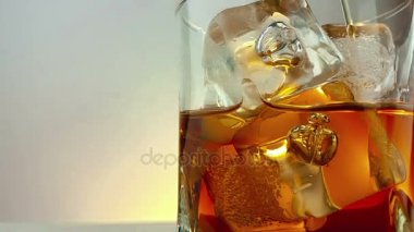 yakın çekim sıcak beyaz arka planda, buz küpleri ile içme cam viski dökme barmen, relax içki viski ile zaman