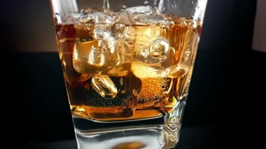 viski içme cam siyah arka plan, buz küpleri ile dökme barmen, yakın çekim zaman relax içki viski, yavaş çekim ile 