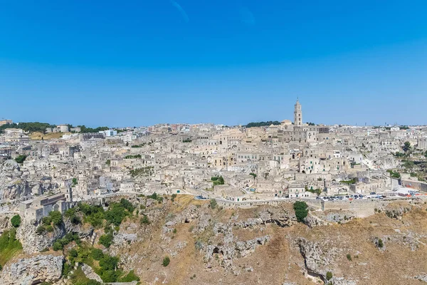 Panoramablick auf typische Steine (sassi di matera) und Kirche von matera UNESCO-Kulturhauptstadt Europas 2019 unter blauem Himmel. Basilikata — Stockfoto
