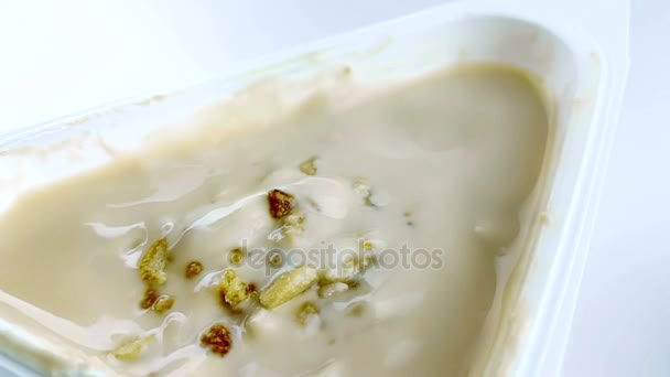 Primer plano de cereales saludables y chocolate cayendo en cámara lenta en el yogur blanco con la cuchara, concepto de comida saludable — Vídeos de Stock