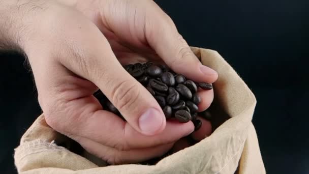 Mano del hombre sosteniendo granos de café en saco de lona y algunos cayendo, tiro cámara lenta, agricultura y nutrición — Vídeo de stock