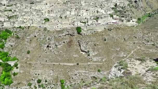 Панорамный вид на типичные камни Sassi di Matera и церковь Matera под голубым небом. Базиликата — стоковое видео