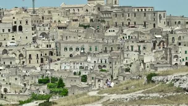 Πανοραμική άποψη του τυπικό πέτρες Sassi di Matera και εκκλησία της Matera κάτω από το γαλάζιο του ουρανού. Μπαζιλικάτα, Ιταλία, σμίκρυνση κάμερα — Αρχείο Βίντεο