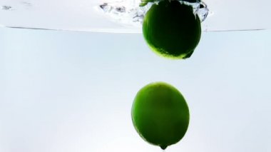 limon meyve splash beyaz kokteyl ve beyaz arka plan, eğlenceli, beslenme ve içki ağır çekimde atış cam, içme suyu içine düşme 