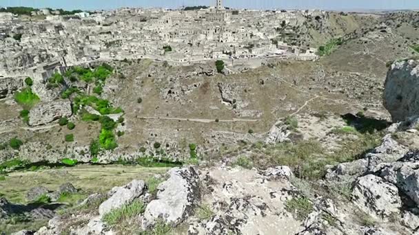 Vista panorámica de las piedras típicas Sassi di Matera y la iglesia de Matera bajo el cielo azul. Basilicata, Italia, alejar la cámara — Vídeos de Stock