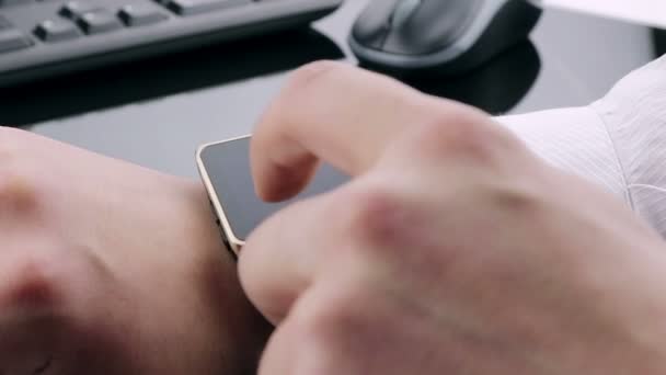 Άνθρωπος των επιχειρήσεων χρησιμοποιώντας την εφαρμογή smartwatch κοντά στο πληκτρολόγιο και το ποντίκι υπόβαθρο, νέα τεχνολογία — Αρχείο Βίντεο