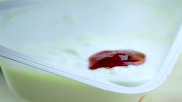 Κοντινό πλάνο του υγιούς κόκκινη φράουλα πέφτουν σε λευκό γιαούρτι, έννοια της υγιεινής διατροφής — Αρχείο Βίντεο