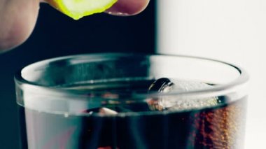 adam sıkmak sarı limon taze kokainle içki cam buz küpleri siyah arka plan, eğlenceli ve yaz saati ile 