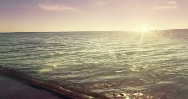 Mar tropical caribenho praia com areia dourada sob o céu por do sol com nuvens e luz solar quente, com brilho na superfície do mar, férias, relaxar e viajar — Vídeo de Stock