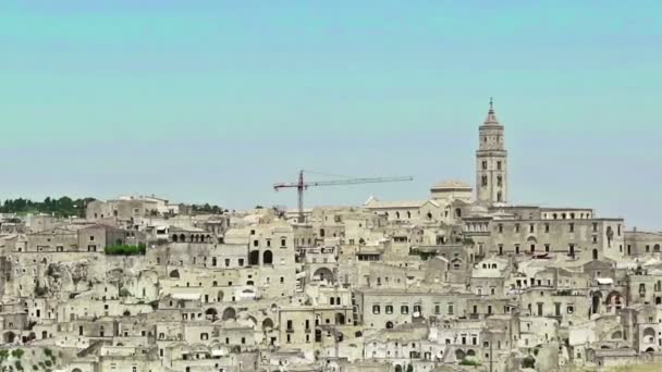 Vista panorámica de las piedras típicas Sassi di Matera y la iglesia de Matera bajo el cielo azul. Basilicata, Italia — Vídeo de stock