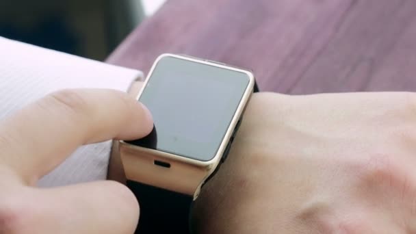 homme d'affaires en utilisant son application smartwatch près de fond de table en bois, nouvelle technologie  