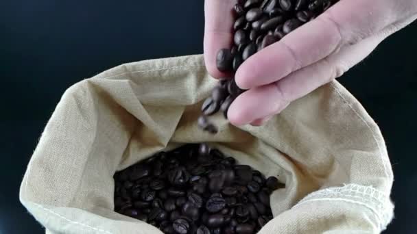 Manos de hombre sosteniendo granos de café en saco de lona y algunos cayendo, tiro cámara lenta, agricultura y nutrición — Vídeo de stock