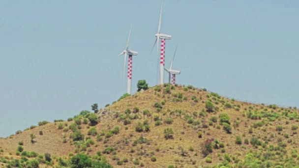 Альтернативная возобновляемая энергия ветряных турбин на фоне холмов под голубым — стоковое видео