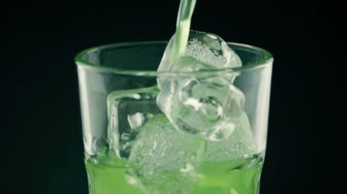 dökülen sarı içki alkol kokteyl cam buz küpleri siyah arka plan, kesilmiş limon ile üç sahne ile içine 
