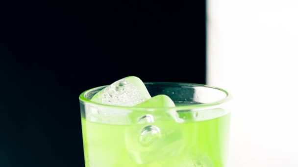 Close-up van man knijp gele citroen op drinken alcohol cocktail in het glas met ijsblokjes, leuke club licht — Stockvideo
