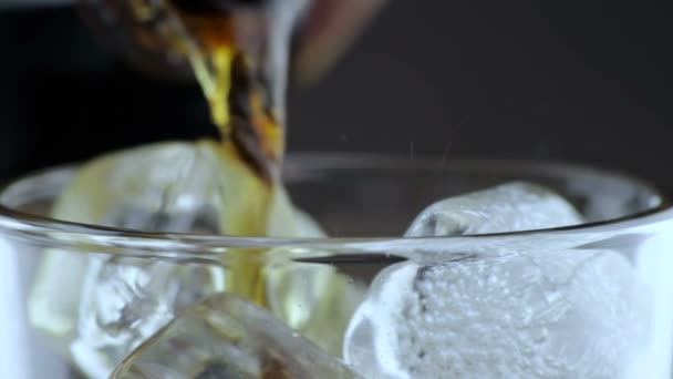 Крупным планом заливки свежего кокса в стакан с кубиками льда на черном фоне, развлекательная и летняя концепция, три сцены с лимоном — стоковое видео