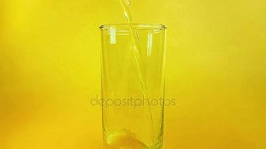 ağır çekim, diyet ve sağlıklı beslenme ve yaz saati ile çekim portakal altın arka plan üzerinde cam içme içine dökme taze portakal suyu 