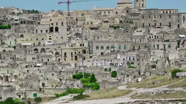 Vista panoramica sui tipici Sassi di Matera e sulla chiesa di Matera sotto il cielo azzurro. Basilicata, Italia, zoom out camera — Video Stock