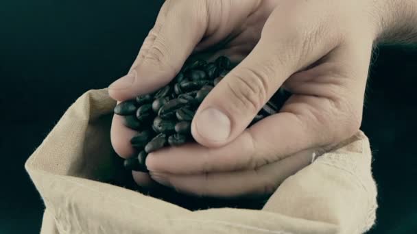 Man hands holding coffee beans in canvas sack and some falling down, shot slow motion, agriculture and nutrition — Stock Video