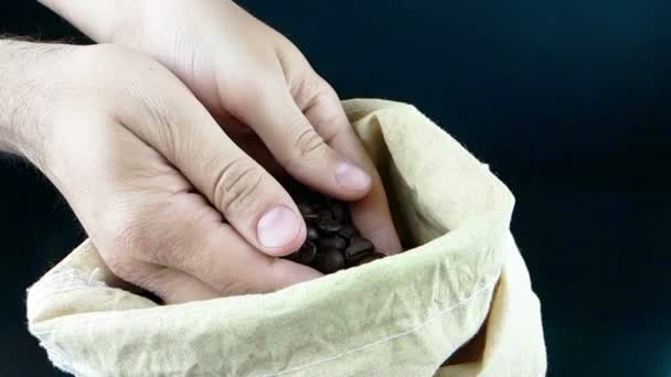 Man hands holding coffee beans in canvas sack and some falling down, shot slow motion, agriculture and nutrition — Stock Video