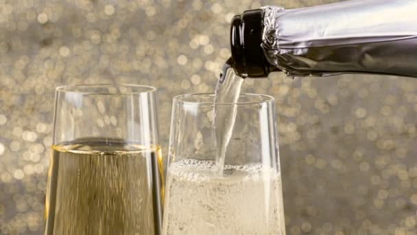 Filling flutes of champagne with golden bubbles against gold bokeh background, concept of golden luxury holiday happy new year — Stock Video