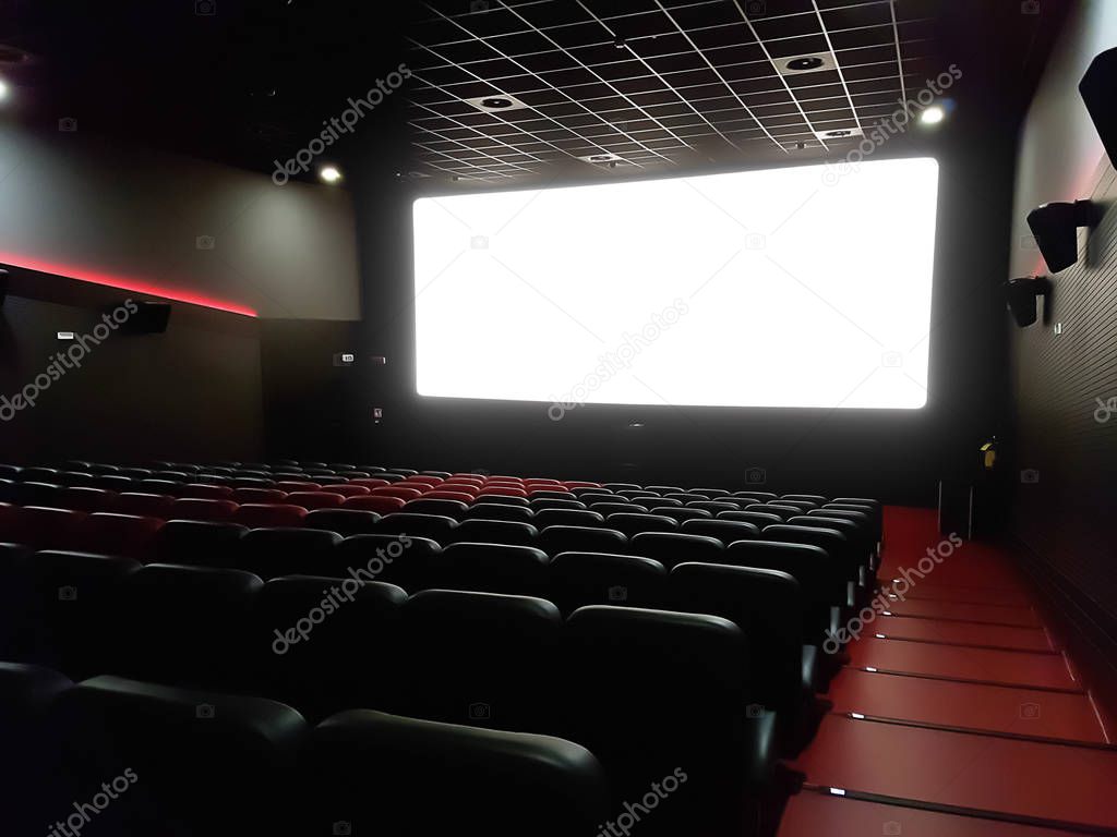 cinema interior of movie theatre with empty red and black seats 