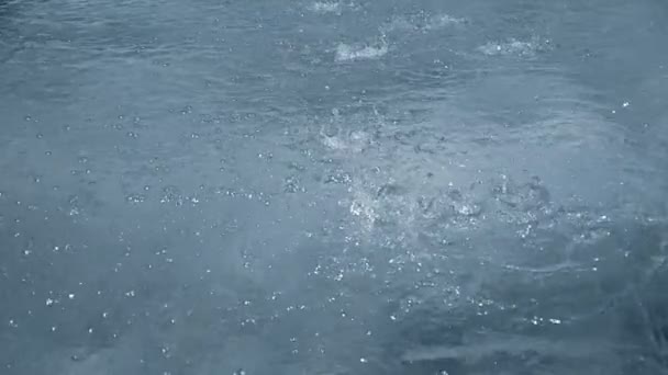 ralenti de fortes gouttes d'eau de pluie ou fontaine sur la rue de surface, boucle sans soudure prêt 