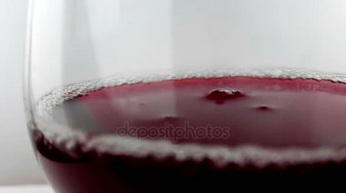 kırmızı şarap damla aşağı düşen içki bardağına yavaş çekimde yüksek hızlı kamera ile çekim beyaz arka plan üzerinde beslenme sağlık kavramı,