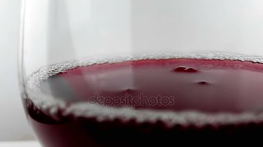 kırmızı şarap damla aşağı düşen içki bardağına yavaş çekimde yüksek hızlı kamera ile çekim beyaz arka plan üzerinde beslenme sağlık kavramı,