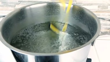 bir mutfak, tencerede kaynamış su içine düşme penne rigate makarna sıçrama vurdu yavaş beyaz arka plan, beslenme ve sağlık kavramı