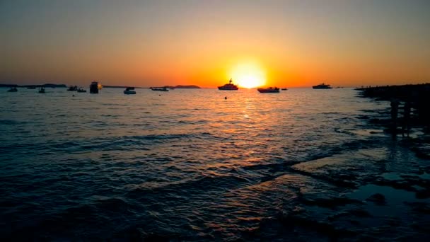 Mar calmo onda ao pôr do sol com sol e barcos no horizonte, conceito de relaxar e viajar de — Vídeo de Stock